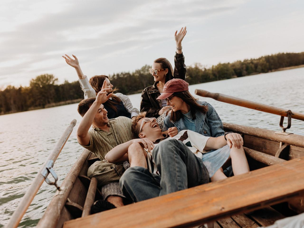 Jugendliche sitzen in einem Ruderboot