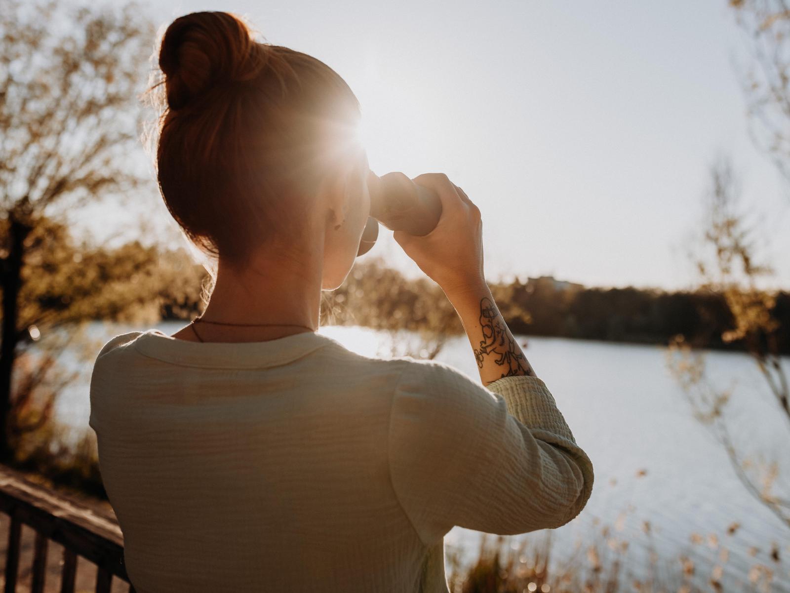 Frau mit Fernglas blickt in Ferne