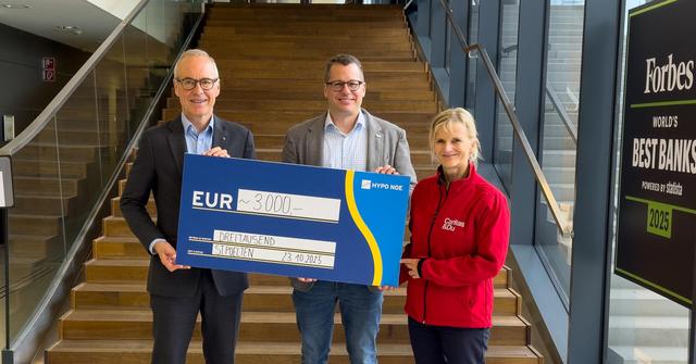 Zwei Männer und eine Frau halten einen Spendenscheck mit der Aufschrift 3.000 Euro.