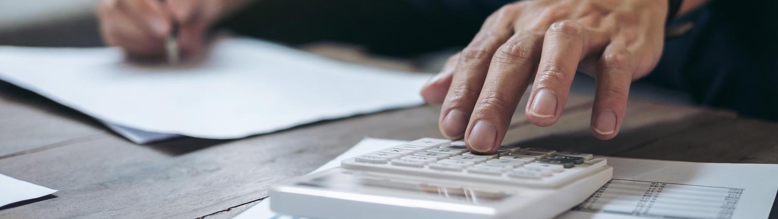 Mann rechnet mit Taschenrechner