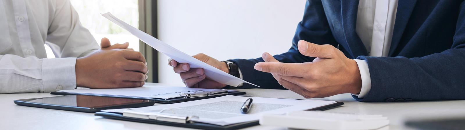 Ein Versicherungsberater erklärt einem Kunden eine Versicherungspolizze